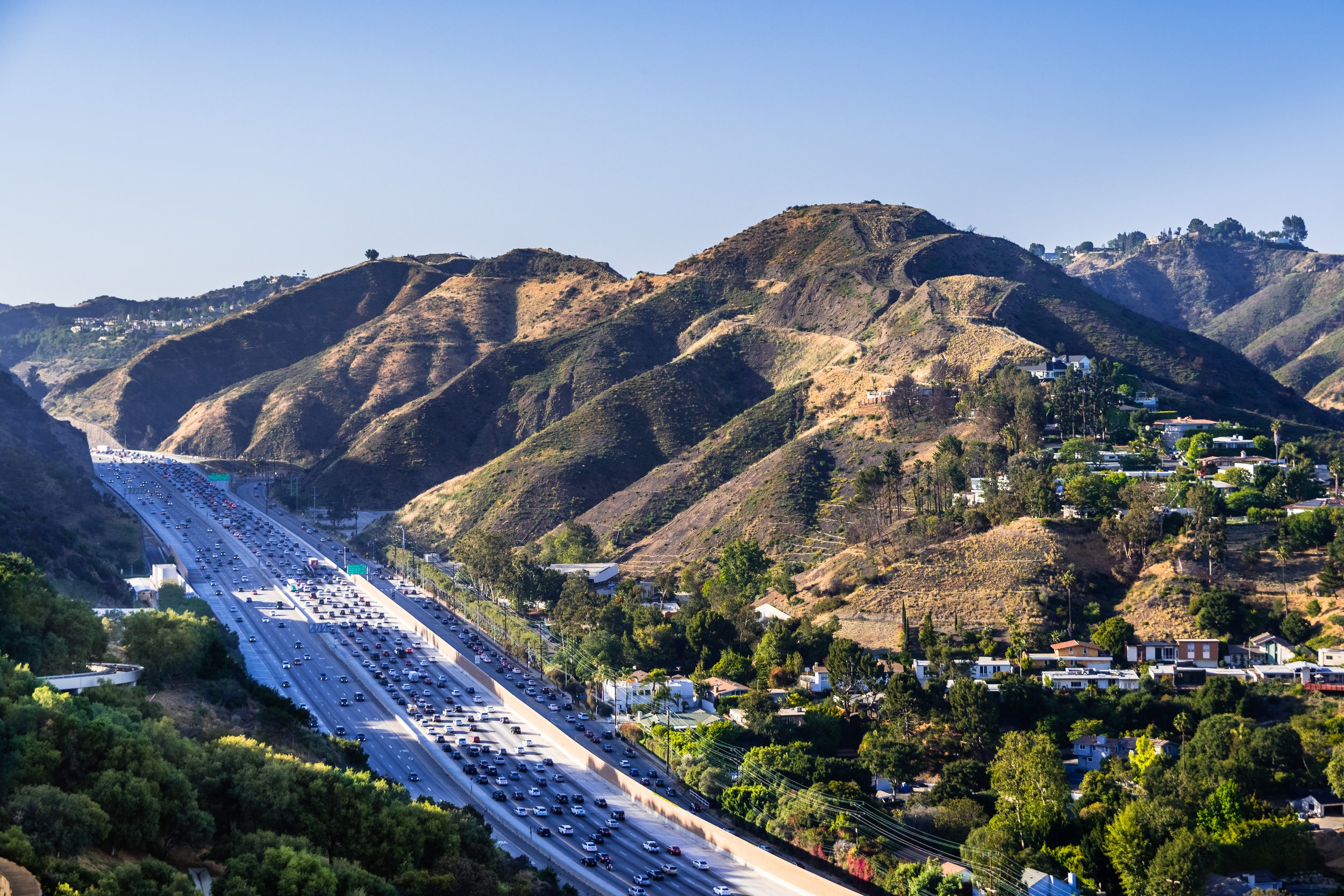Aerial view of highway 405 with heavy traffic; the hills of Bel